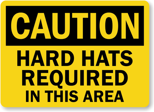 OSHA compliant yellow sign with black text saying 'CAUTION HARD HATS REQUIRED IN THIS AREA'